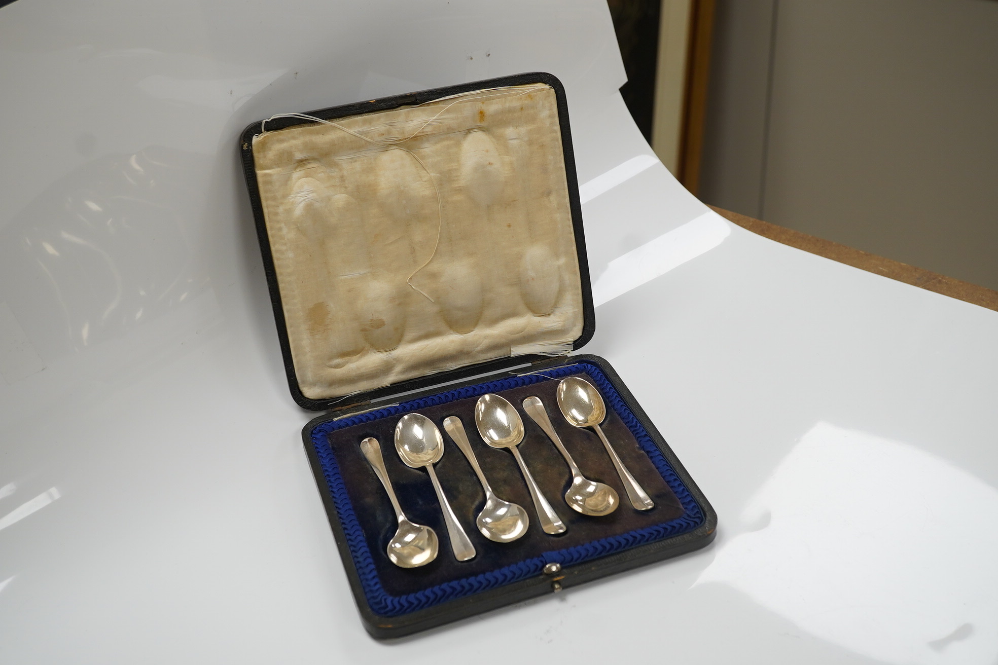 A cased set of six George V silver teaspoons and a cased pair of glass butter dishes with two silver butter knives. Condition - fair to good